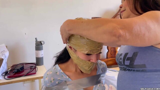 Granny ties up and ball gags young Latina in BDSM toy session